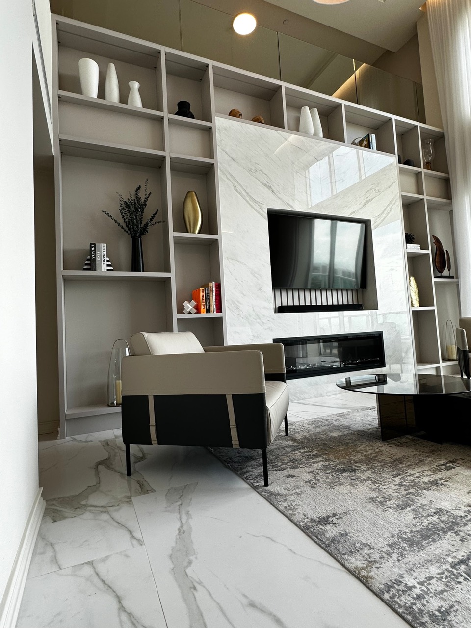 Residential interior with custom shelving and a marble fireplace